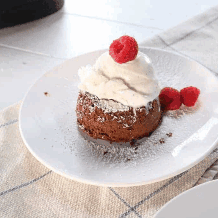 Homemade chocolate lava crunch cakes on a plate, with warm melted chocolate oozing from the center.