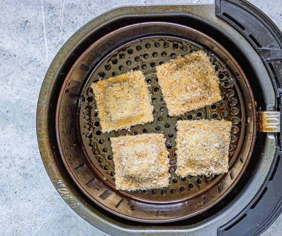 Place the breaded ravioli into the air fryer basket, in a single layer.
