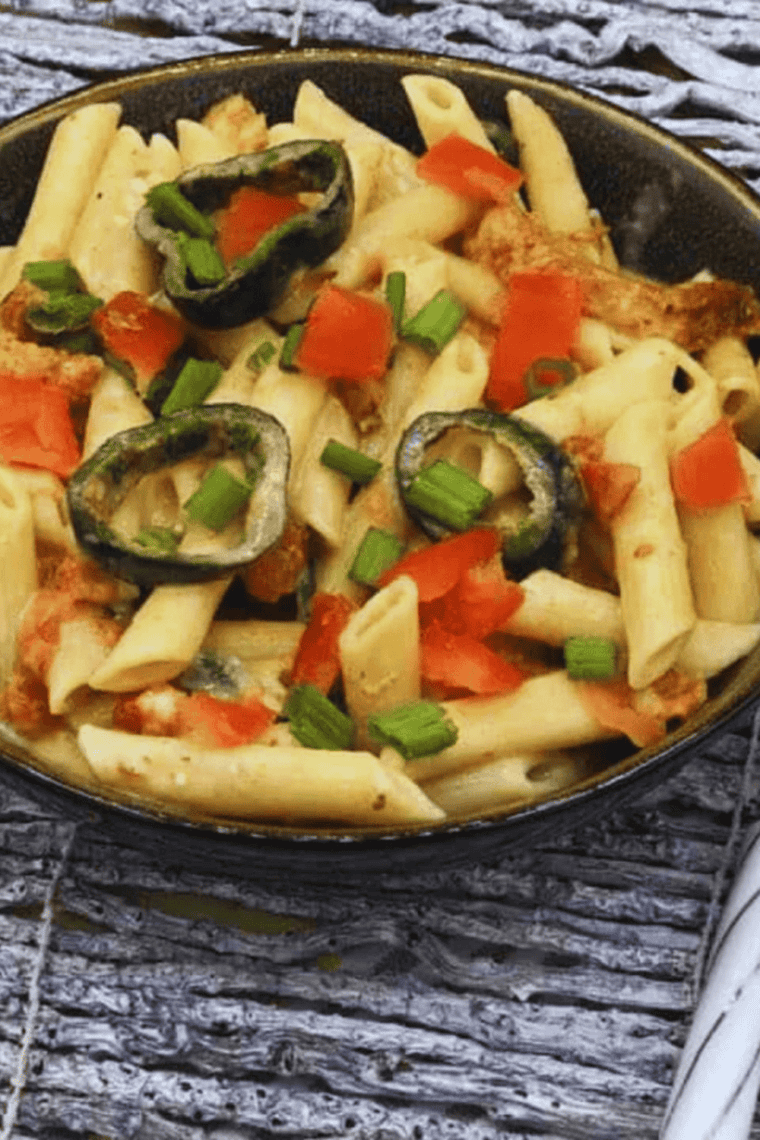 One-pot Instant Pot Cajun Chicken Alfredo with creamy parmesan sauce, penne pasta, and seasoned chicken garnished with parsley.