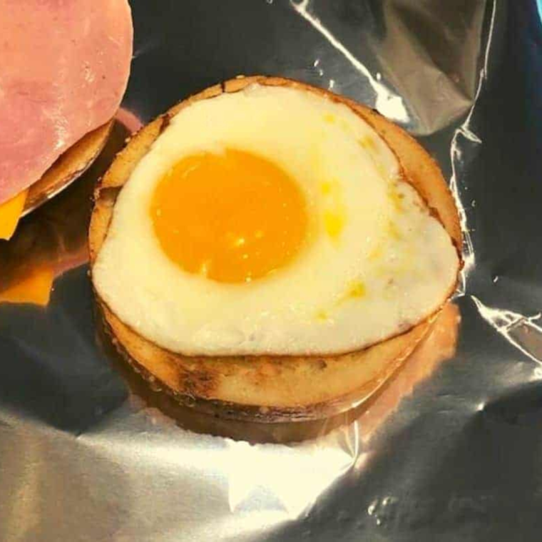 Assembling the egg sandwich in the air fryer basket.