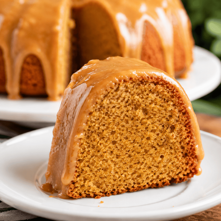 Glazed bundt coffee cake on a cutting board served with coffee