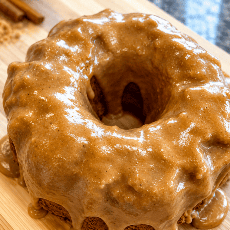Caramel glaze dripping down a bundt coffee cake on a wooden cutting board