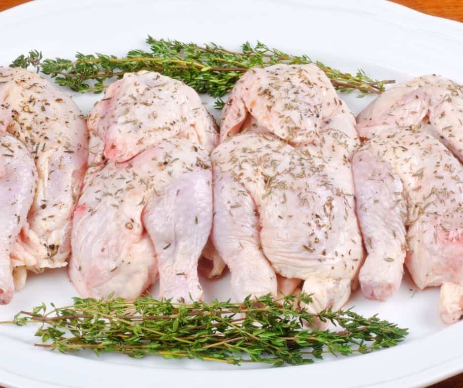Raw Cornish hens with seasoning on them.