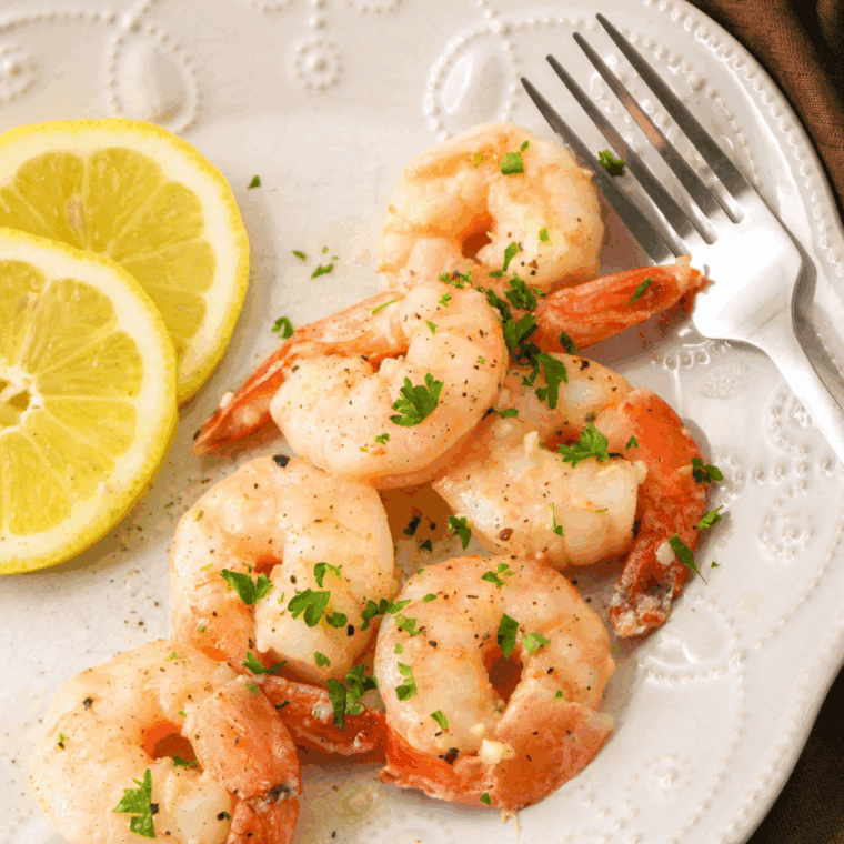 Plate of Carrabba’s Shrimp Scampi with linguine pasta, garnished with fresh parsley and lemon wedges.