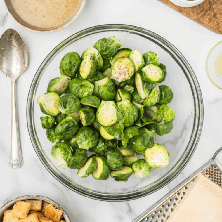 Rinse fresh Brussels sprouts under cold water, trim the stem ends, and cut them in half lengthwise for even cooking.