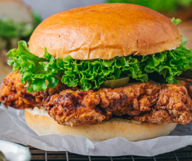 Ina Garten fried chicken sandwich with buttermilk herb mayo, lettuce, and pickles on a toasted potato bun