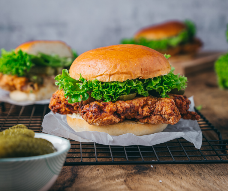 Fried chicken cutlet layered on a toasted potato bun with herb mayo and pickles