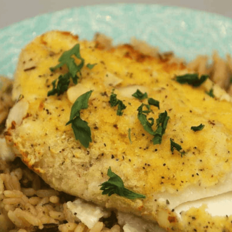 Plate of crispy almond crusted cod fillets with garnish.