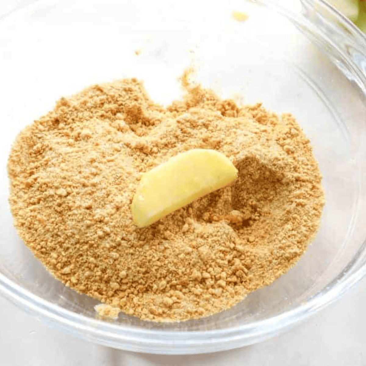 Mixing graham cracker crumbs, sugar, and cinnamon in a bowl