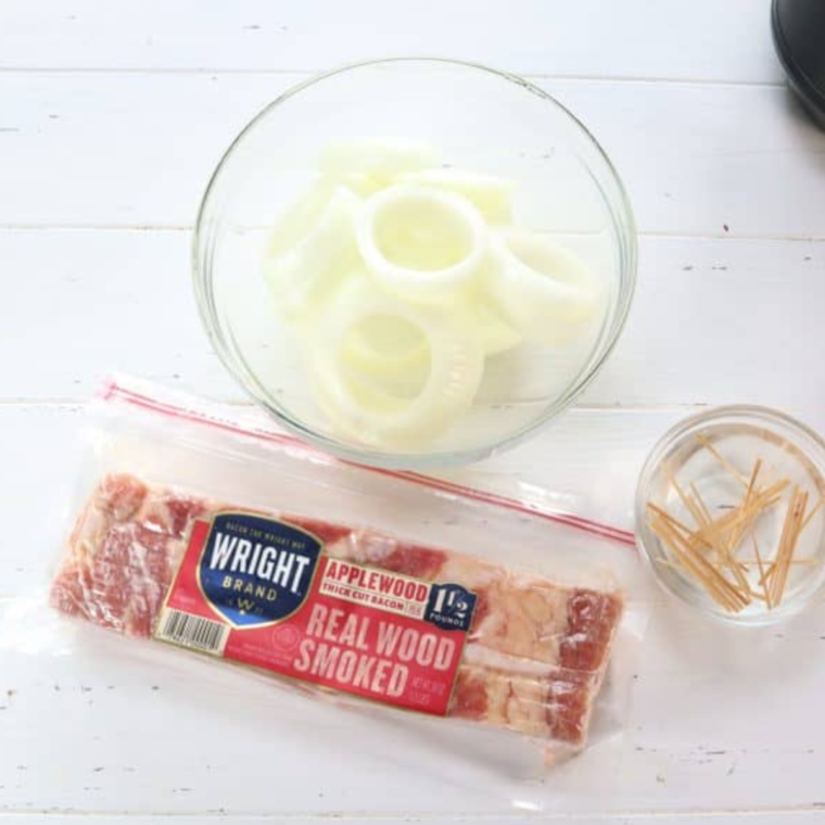 Ingredients needed for Air Fryer Bacon Wrapped Onion Rings on kitchen table.