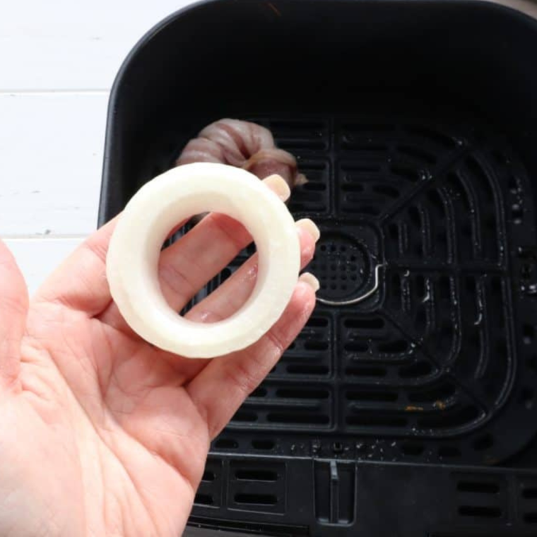 Onion rings separated into 1-inch rings, wrapped with bacon for Air Fryer Bacon Wrapped Onion Rings preparation.