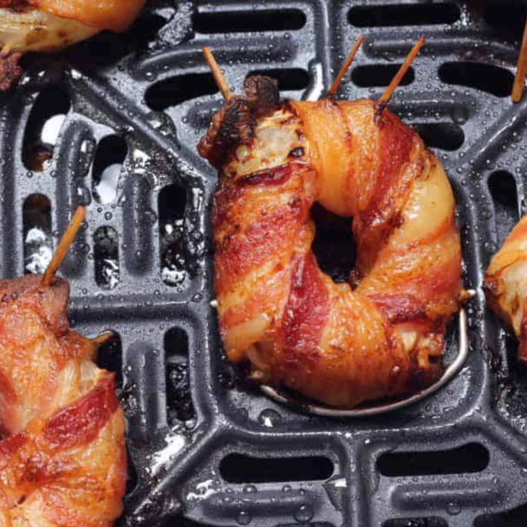 Air fryer set to 375 degrees F, cooking bacon-wrapped onion rings for 8-10 minutes until crispy.