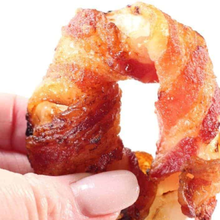 "Golden and crispy bacon-wrapped onion rings cooked to perfection in an air fryer, ready to serve."