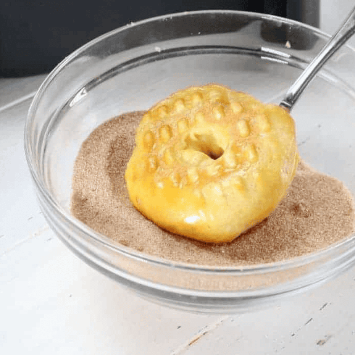Brush melted butter on cronuts, then coat thoroughly in a cinnamon and sugar mixture while still warm, repeating for all cronuts.
