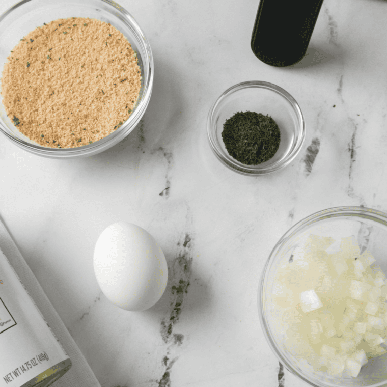 Ingredients for air fryer lobster cakes including cooked lobster meat, egg, panko, and Cajun seasoning