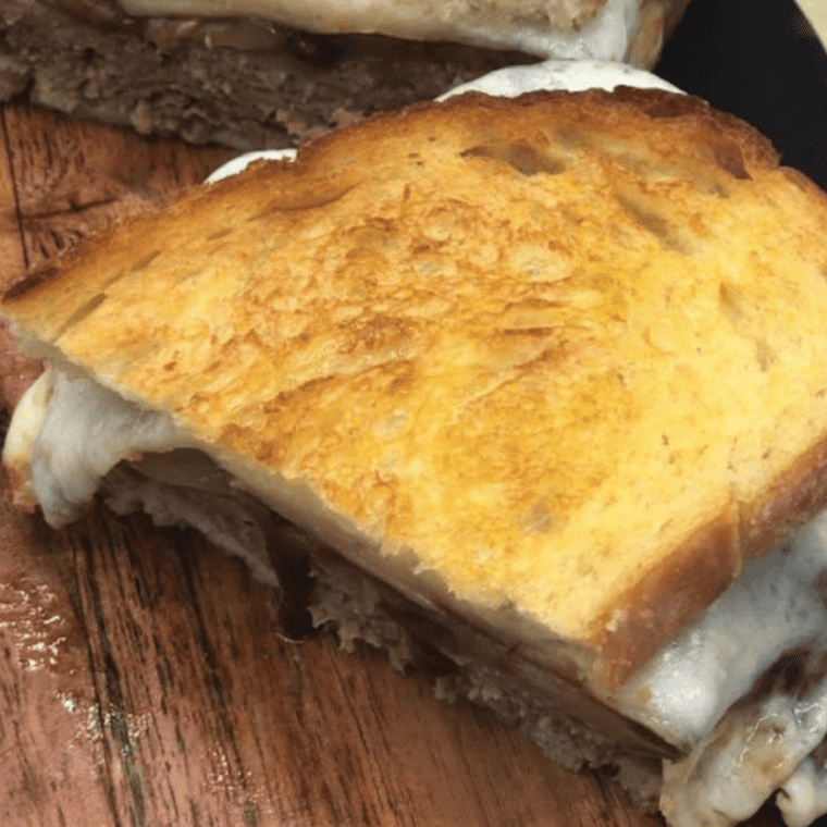 "Golden brown Air Fryer Meatloaf Sandwich with melted cheese oozing out."