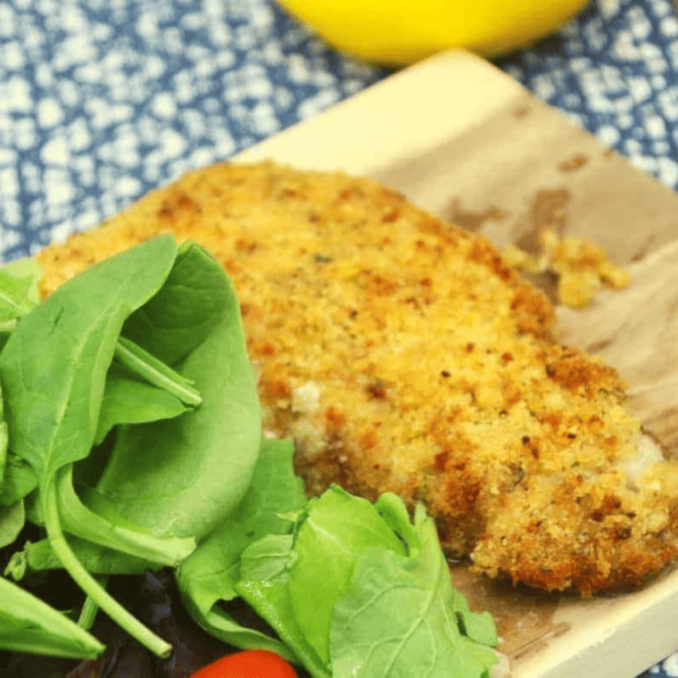 Air Fryer Parmesan Crusted Cod fillets with a crispy, golden crust, served with roasted vegetables and lemon wedges.