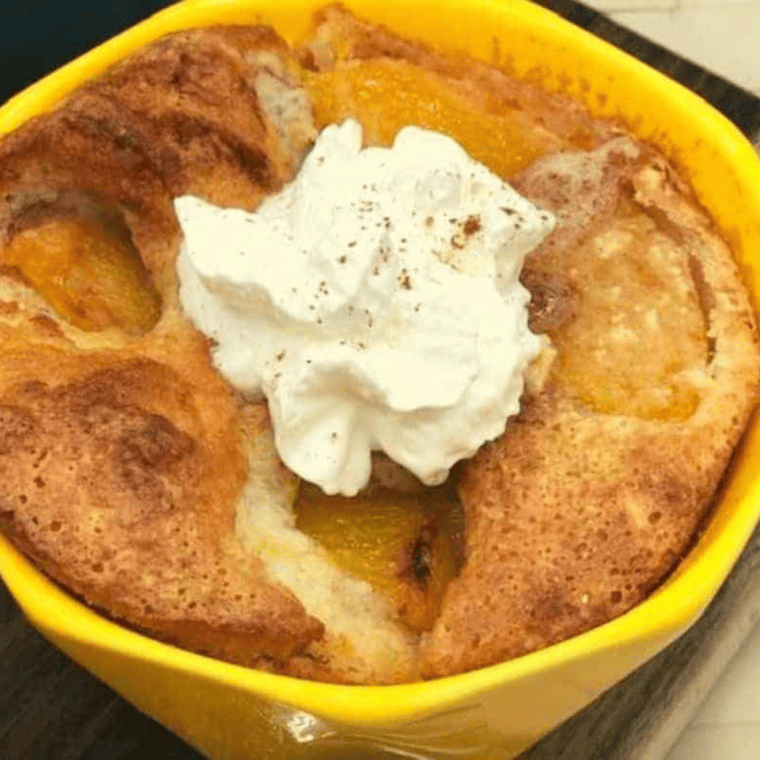 Individual serving of golden-brown peach cobbler cooked in an air fryer, served in a small dish