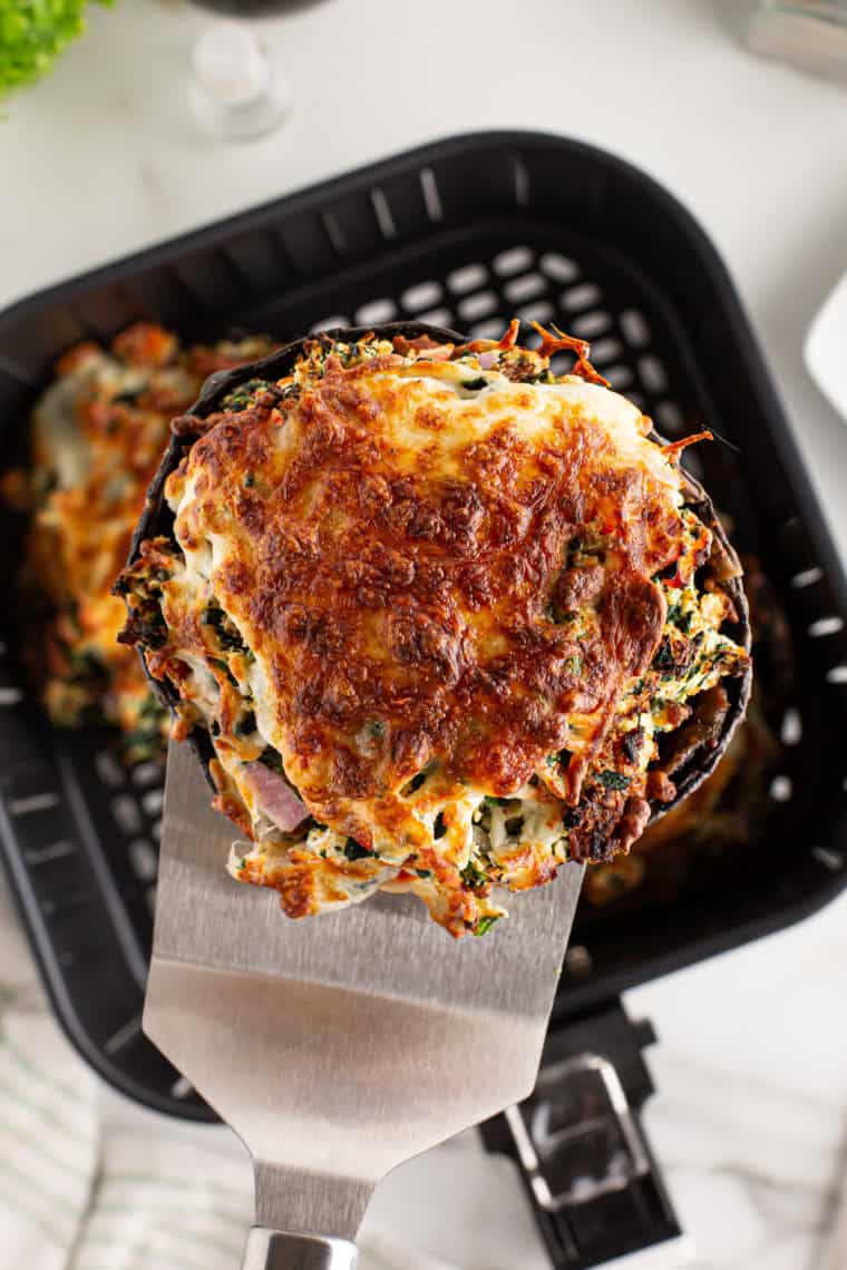 Stuffed mushrooms filled with a savory spinach and Fontina cheese mixture, seasoned with fresh herbs and cooked to perfection in the air fryer.