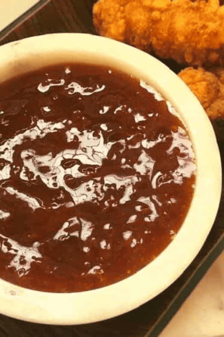 Bowl of bright and glossy apricot sweet and sour sauce ready for serving