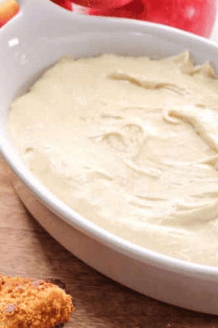 Bowl of smooth, creamy Auntie Anne’s sweet caramel dip with pretzel for dipping
