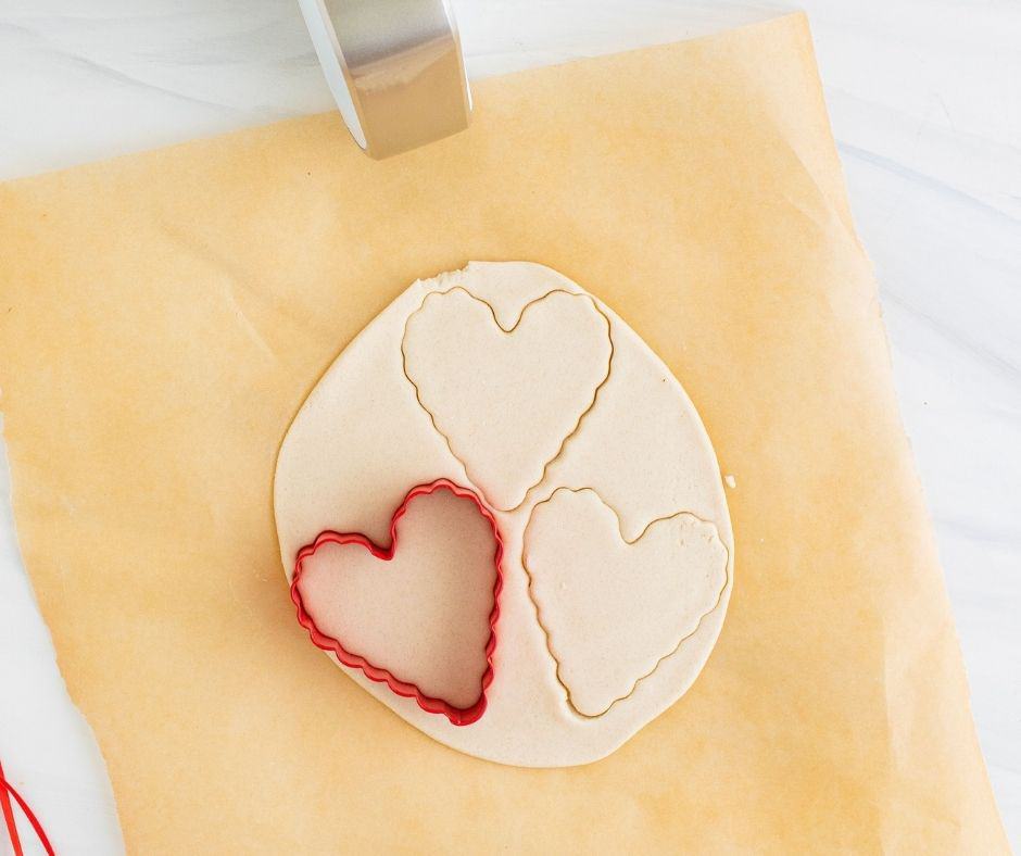 Preheating the air fryer to 300°F and rolling out dough on parchment paper to 1/4-inch thickness.