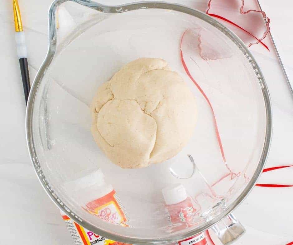 Mixing flour, salt, and water to form a smooth dough ball using a stand mixer with a dough hook.