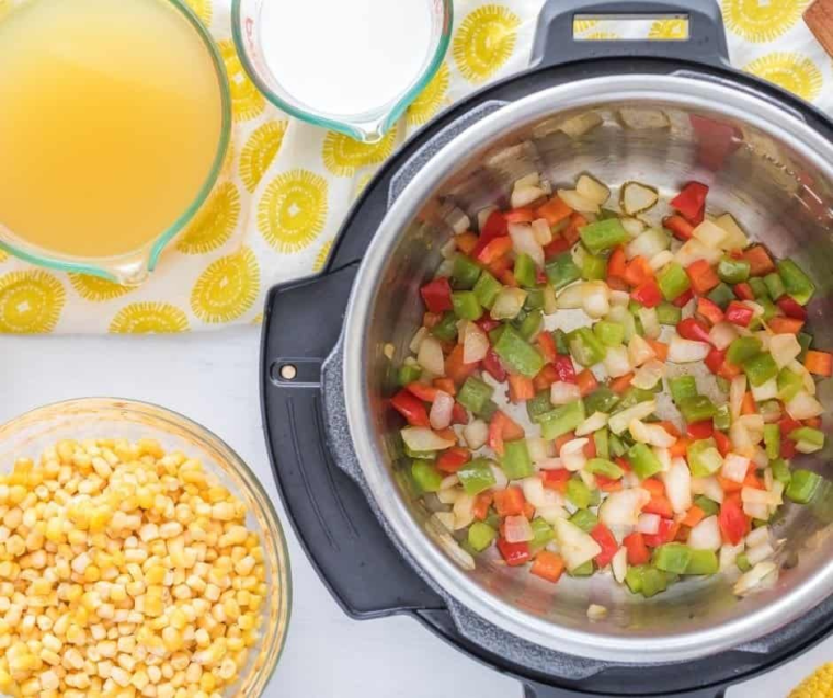 "Step-by-step process showing the corn and vegetables sautéing in the Instant Pot before adding liquid."
