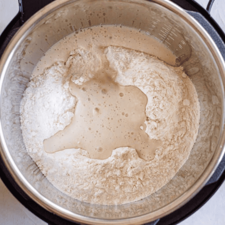 yeast and sugar mixed with lukewarm water in glass to activate