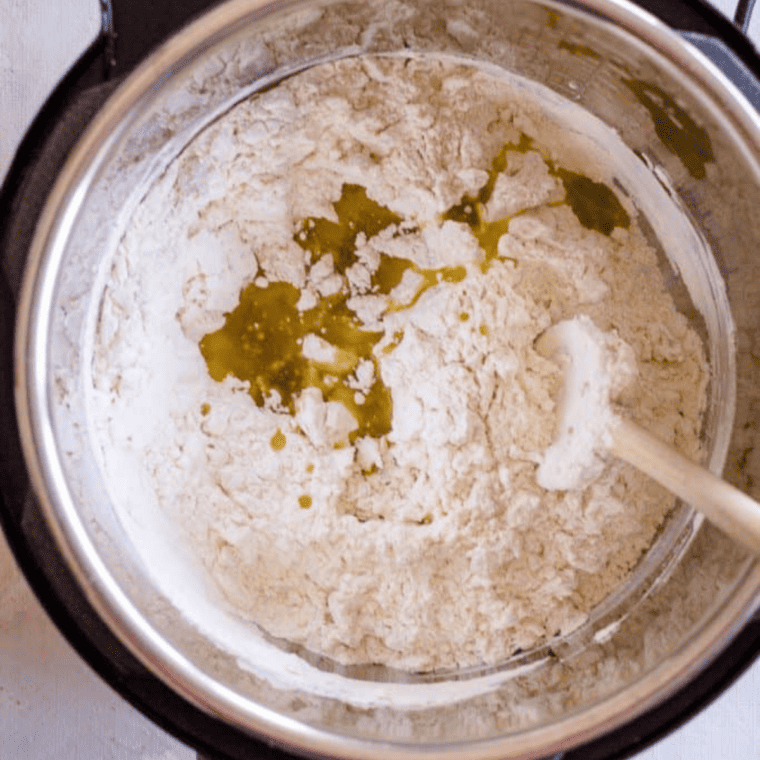 flour, salt, and activated yeast mixed in Instant Pot with olive oil and water forming soft dough