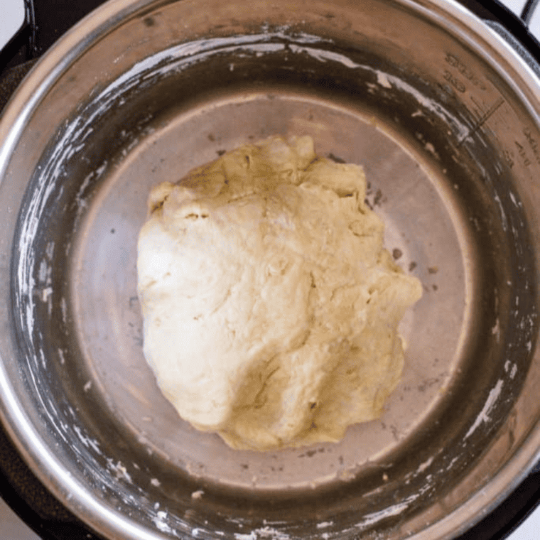 dough shaped into ball resting in Instant Pot covered with lid or wrap