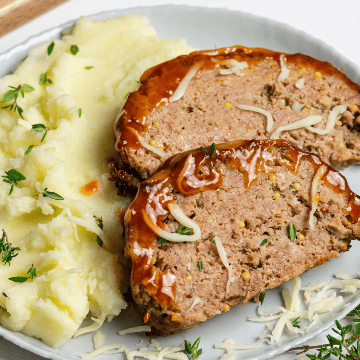 Sliced Joanna Gaines meatloaf topped with ketchup glaze on a dinner plate.