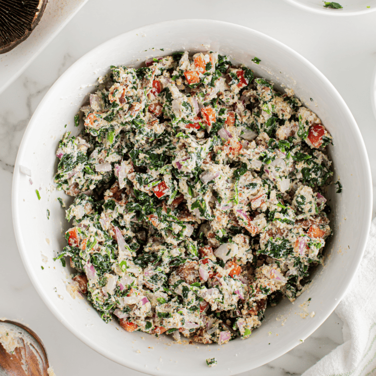 Mix sautéed spinach, garlic, herbs, Fontina cheese, breadcrumbs, and seasonings in a bowl.
