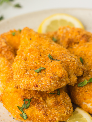 Golden brown chicken cutlets cooked in Ninja Crispi air fryer basket.