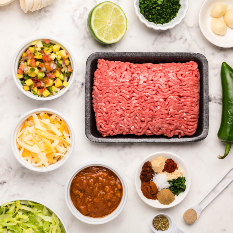 Ingredients for air fryer taco pie: flour tortillas, refried beans, ground beef, taco seasoning, and shredded cheese