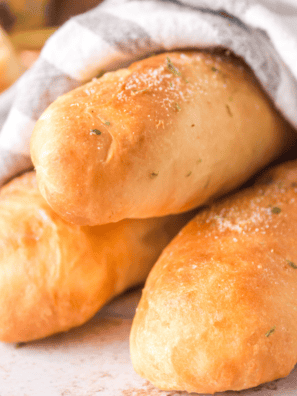 Golden air fryer breadsticks made from pizza dough, dusted with parmesan and herbs