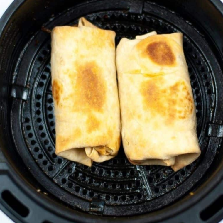 Crispy golden-brown air fryer breakfast chimichangas in the basket after cooking