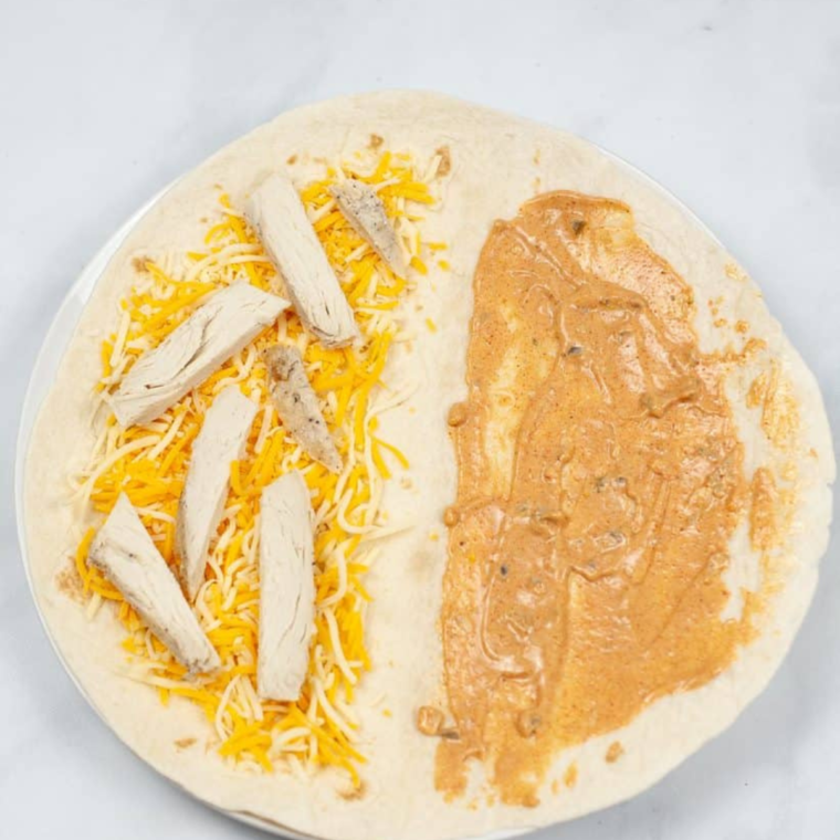 air fryer quesadilla cooking folded tortilla sprayed with oil crisping on both sides and held closed to prevent cheese leaking while air frying