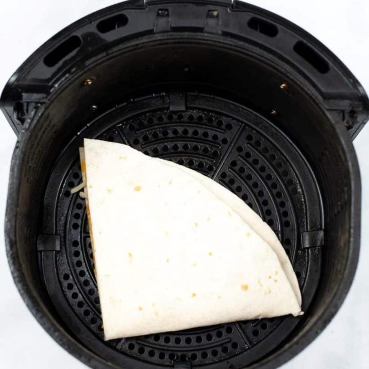 air fryer quesadilla resting briefly before slicing into wedges and served with creamy jalapeño dipping sauce