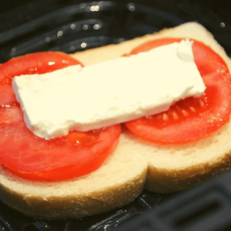 "Close-up of Air Fryer Feta, Tomato, and Basil Grilled Cheese, showcasing its crispy crust and fresh ingredients."