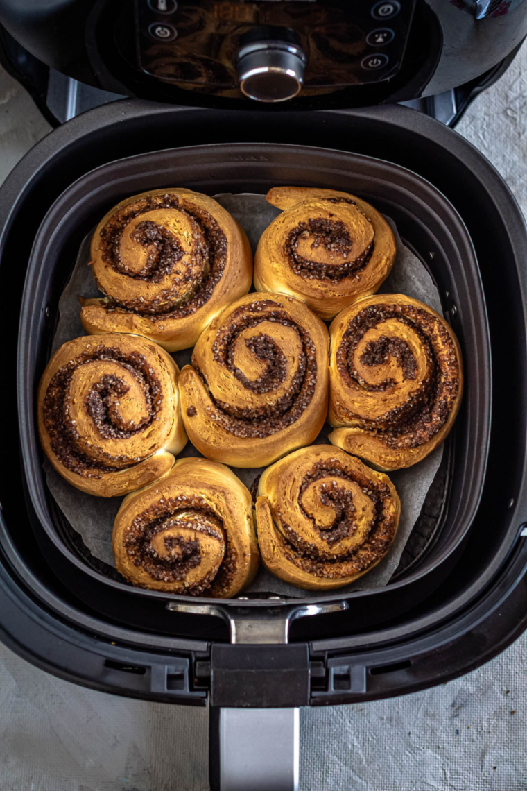 Close-up of warm homemade cinnamon rolls with gooey cinnamon filling and cream cheese frosting.