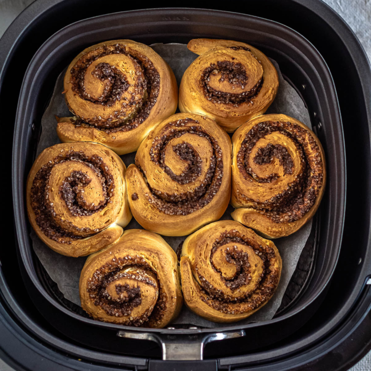 Freshly baked homemade cinnamon rolls with swirled cinnamon and cream cheese frosting.