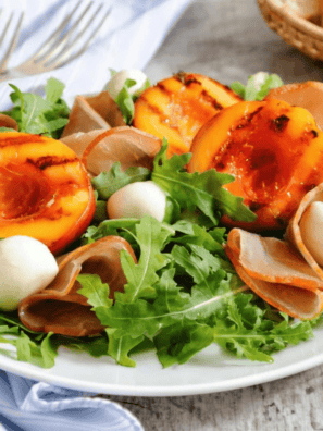 Air fryer grilled nectarines topped with whipped cream on a white plate