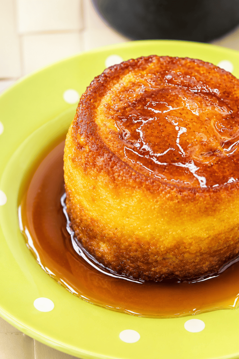 Golden brown Air Fryer Pancake Muffins on a white plate topped with maple syrup.