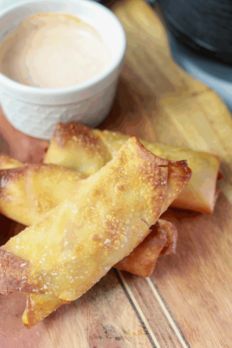 Crispy golden Air Fryer Pickle Egg Rolls on a plate with dipping sauce.