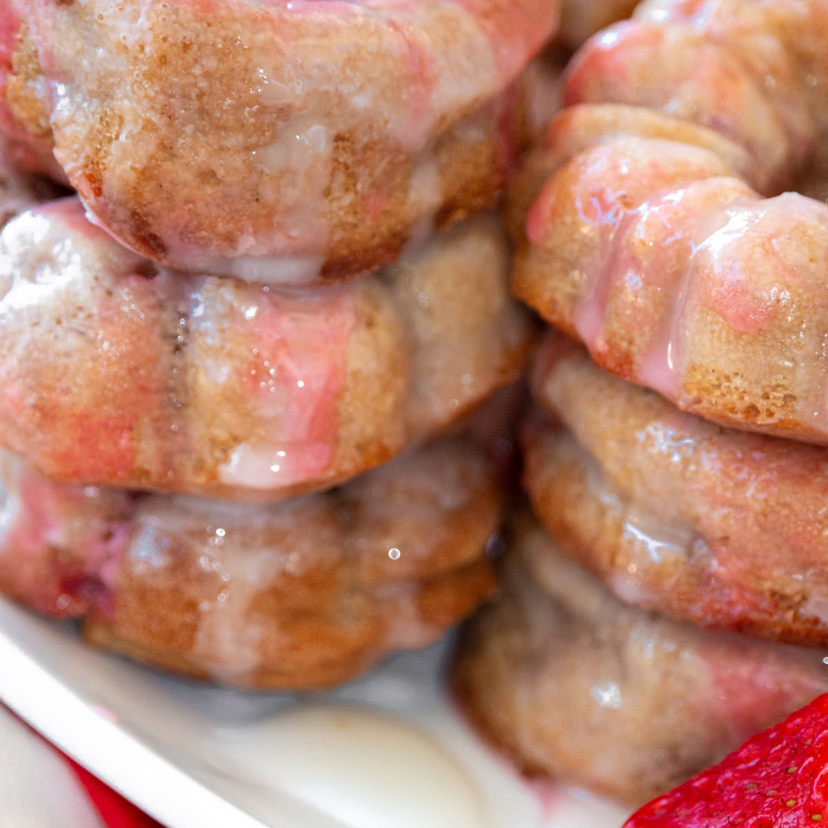 Stack of glazed air fryer strawberry donuts ready to serve