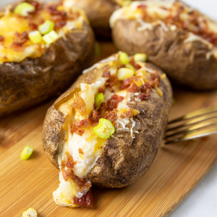 Close-up of an air fryer twice baked potato with a creamy cheddar filling and crispy skin