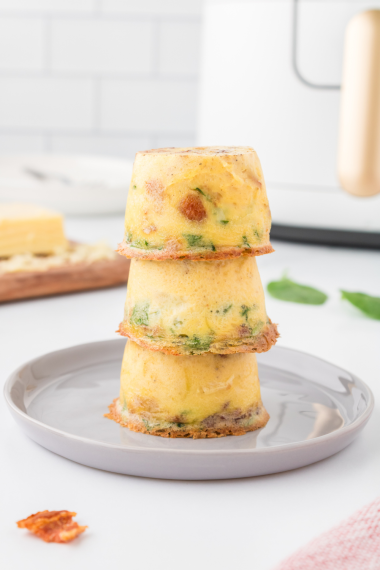 Single keto egg bite on a plate, close up on the fluffy texture and golden top