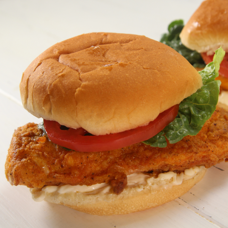 Air Fryer Wendy's Spicy Chicken Sandwich with crispy chicken, pickles, lettuce, tomato, and mayonnaise on a soft bun.