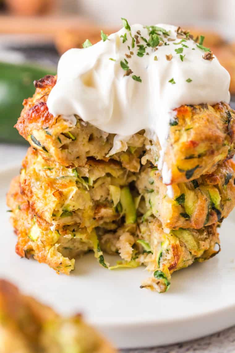 "Crispy golden Air Fryer Zucchini Fritters served on a plate, garnished with fresh herbs and a side of dipping sauce."